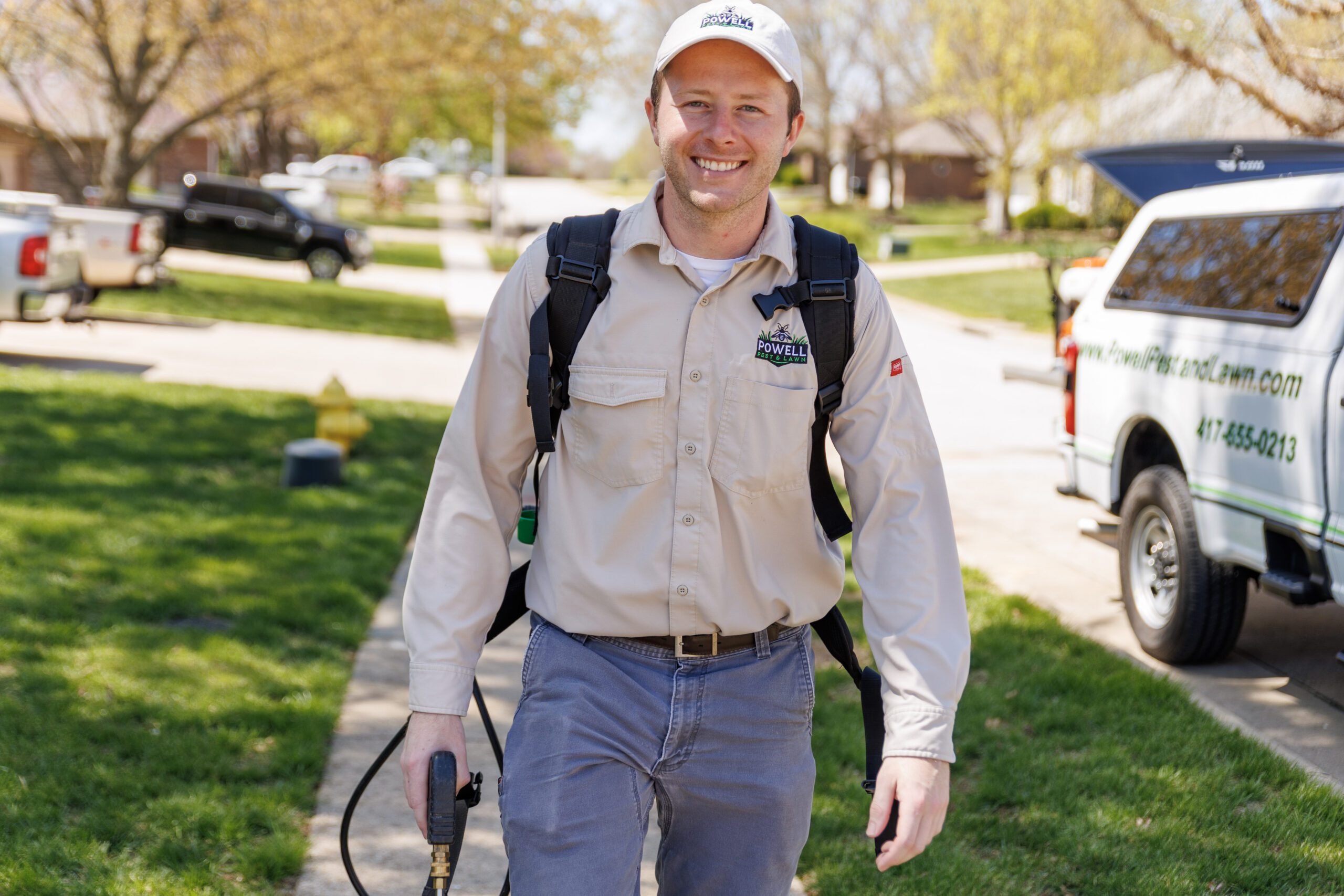 CSP_9414 Powell Pest and Lawn technician standing outside a home