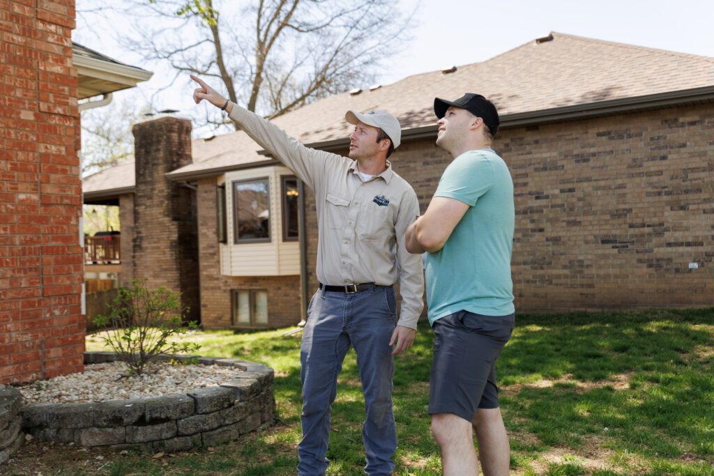 Powell Pest and Lawn technician discussing pest control with a customer outside a home