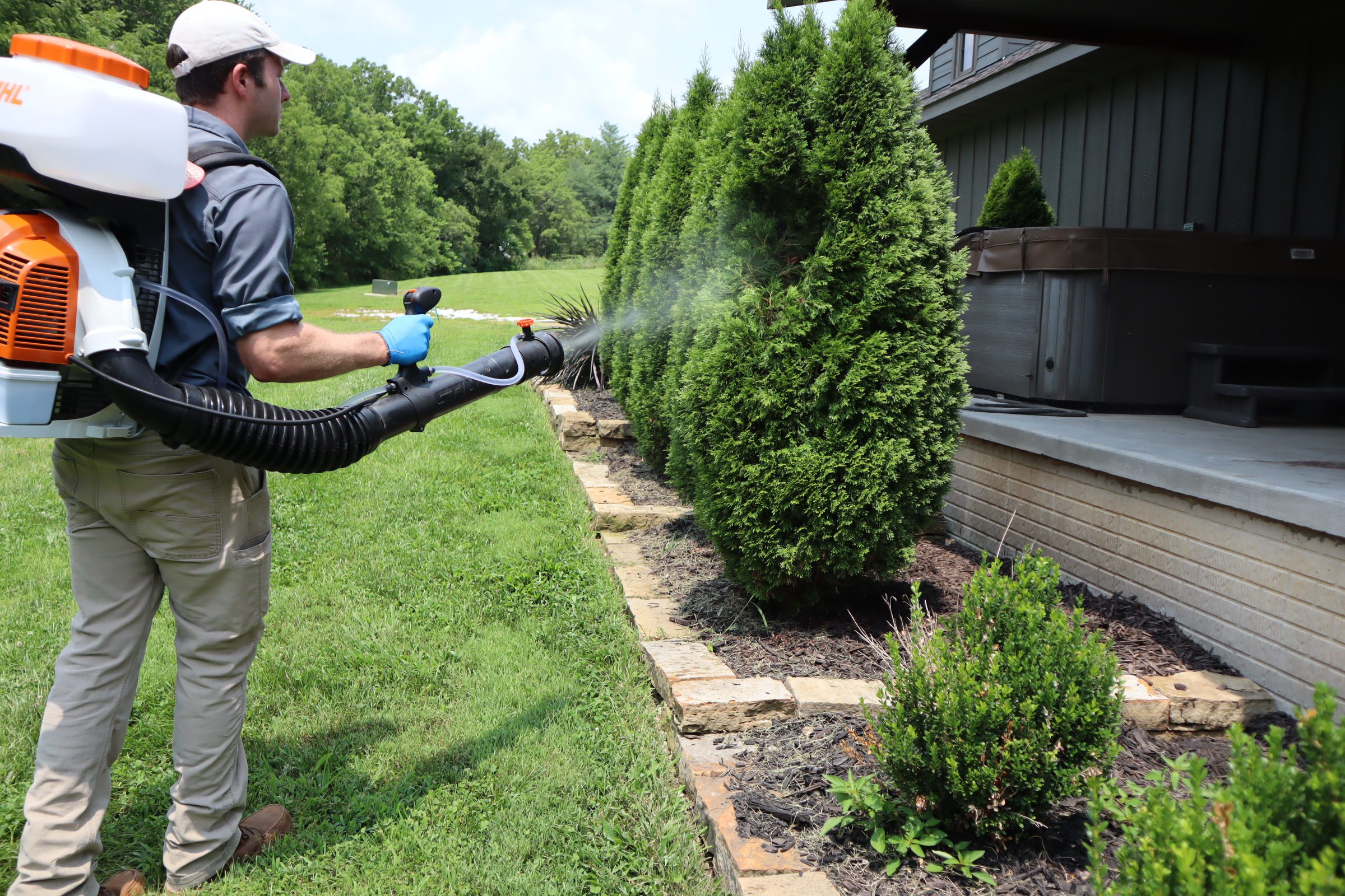 Mosquito treatment around residential landscaping Powell Pest and Lawn applying mosquito treatment to residential landscaping